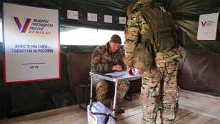 Российский военнослужащий голосует во время досрочного голосования вблизи линии фронта
