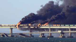 Черный дым над Крымским мостом после взрыва грузовика, в результате которого погибли три человека.  
