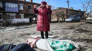 Женщина плачет над телами жертв ракетного удара в городе Пантелеймоновка в подконтрольной России части Донецкой области.