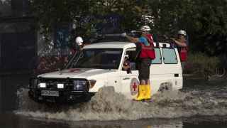 Работники Красного Креста едут по затопленной улице Херсона
